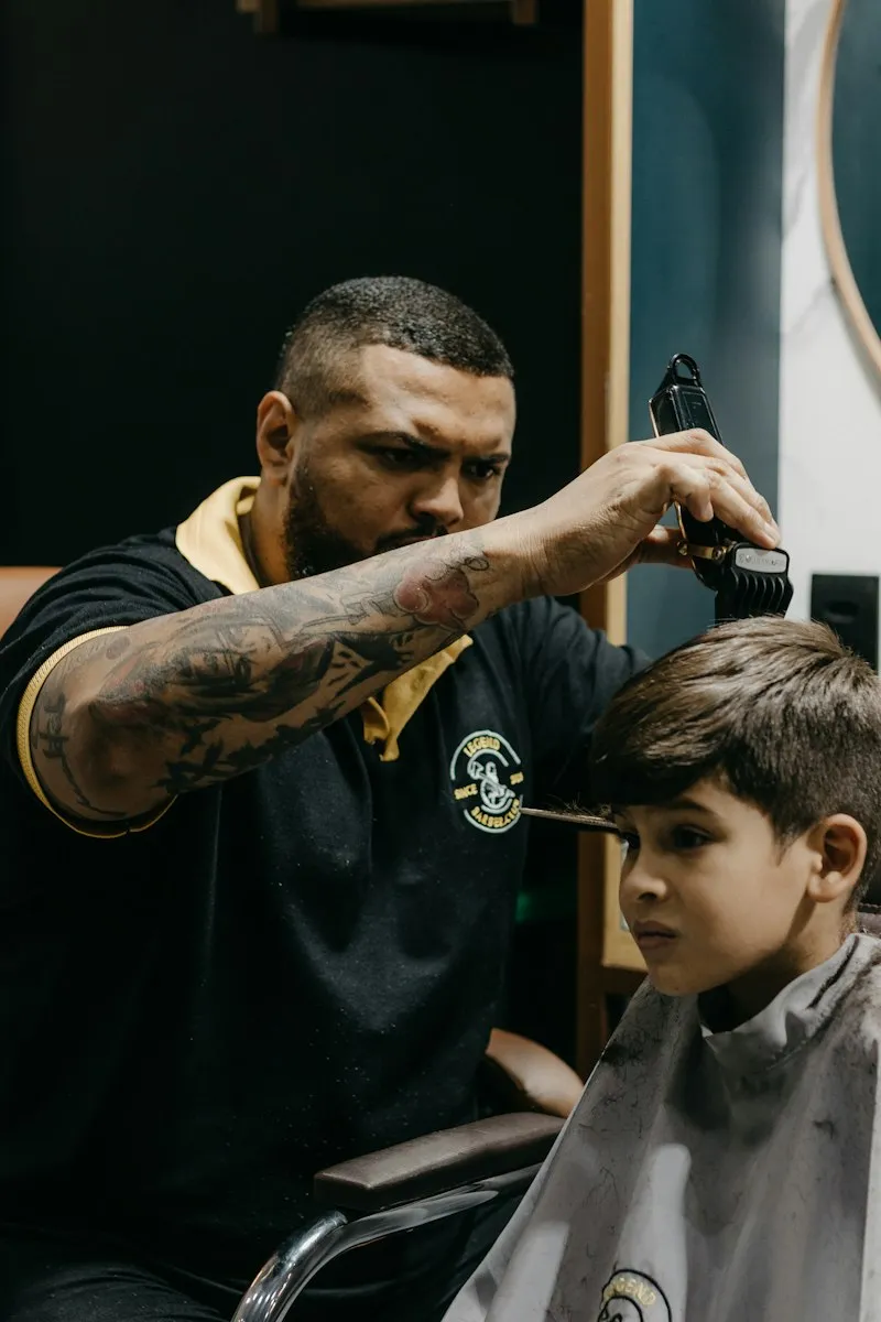 Barbier réalisant un dégradé sur un jeune garçon