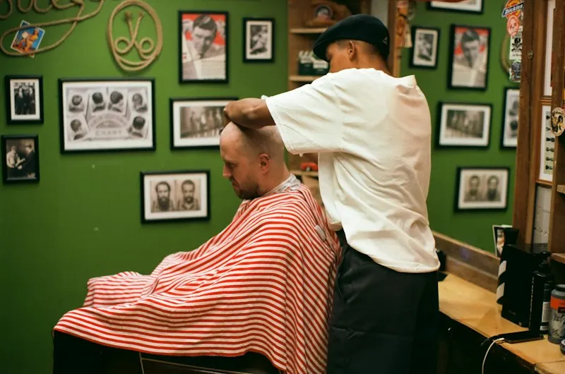 Barbier réalisant un dégradé à la tondeuse