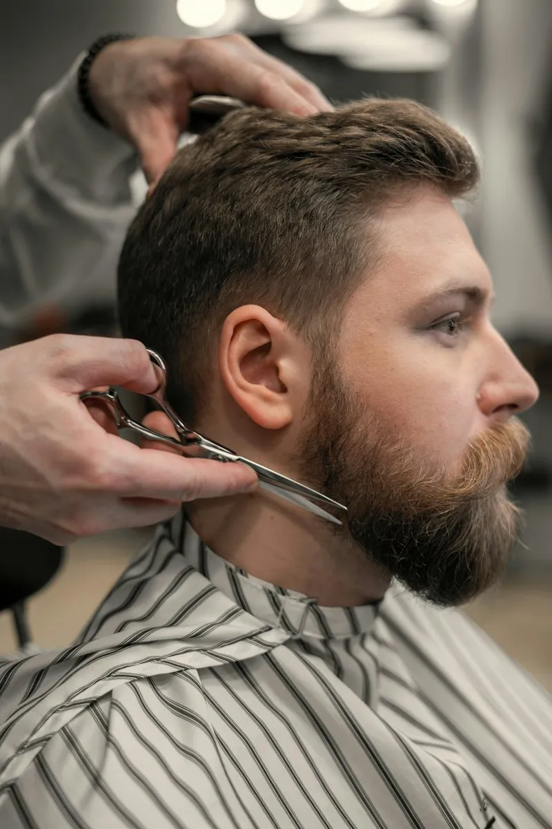 Barbier taillant une barbe aux ciseaux