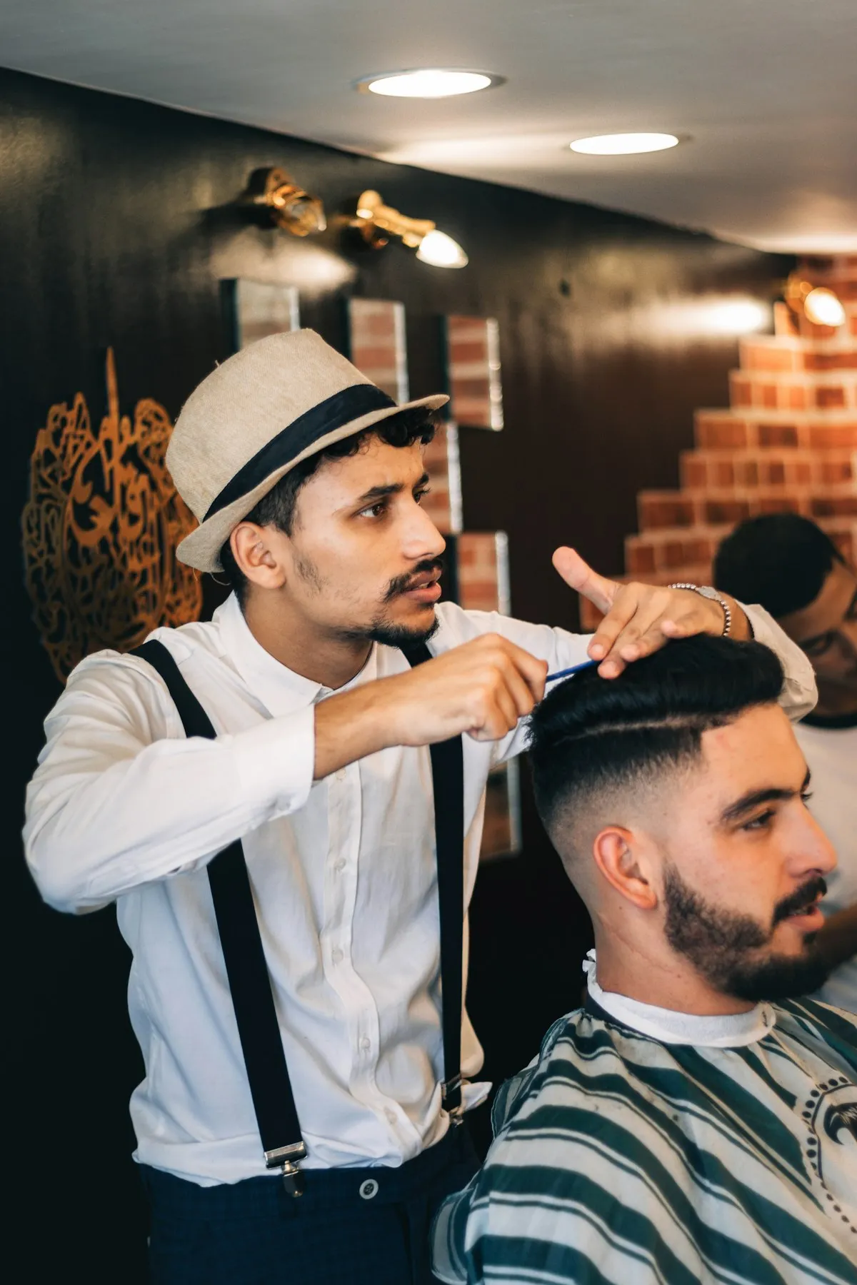 Barbier coiffant les cheveux d’un client au peigne avant la coupe