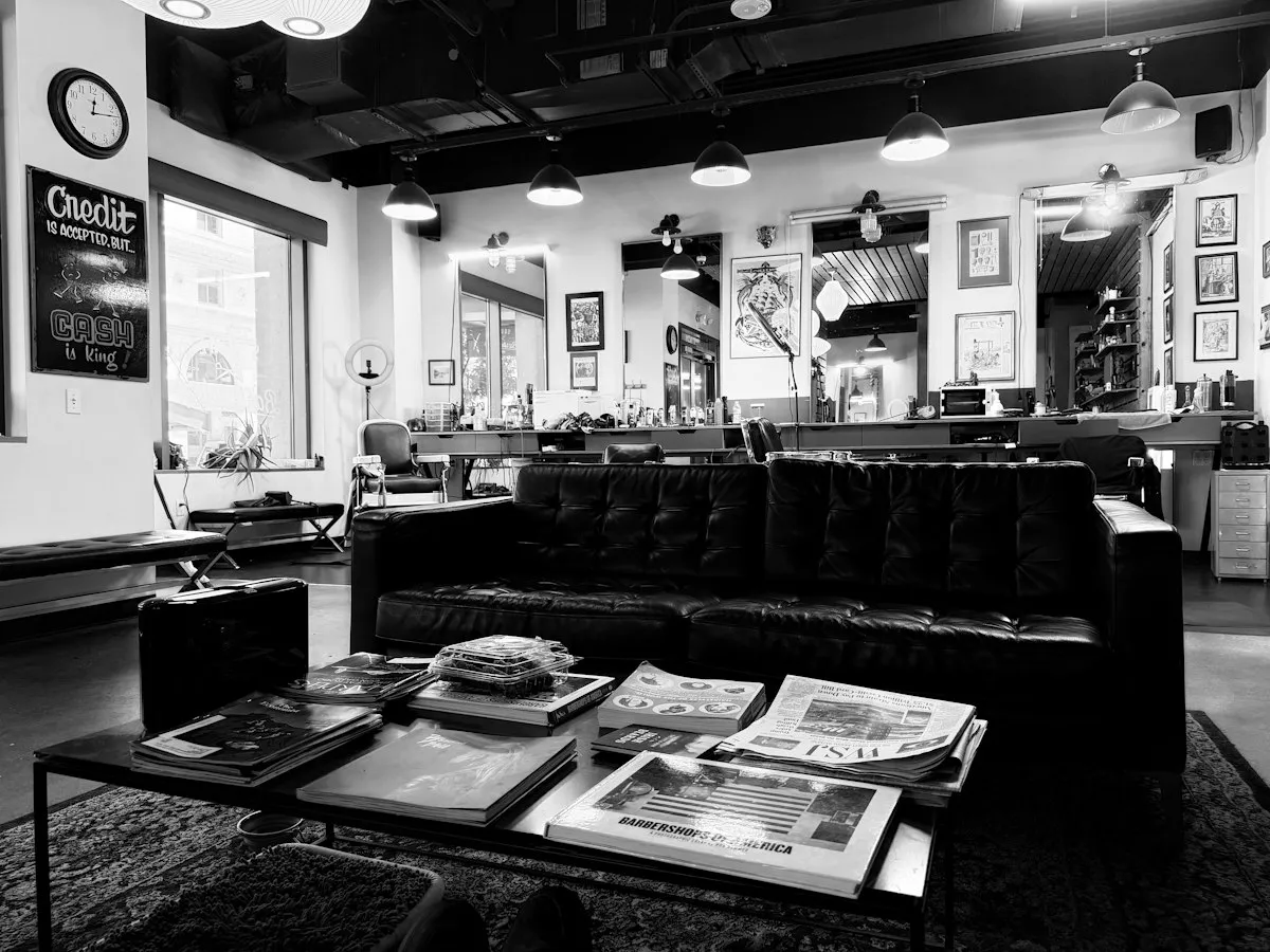 Espace d’attente d’un salon de barbier avec canapé et magazines