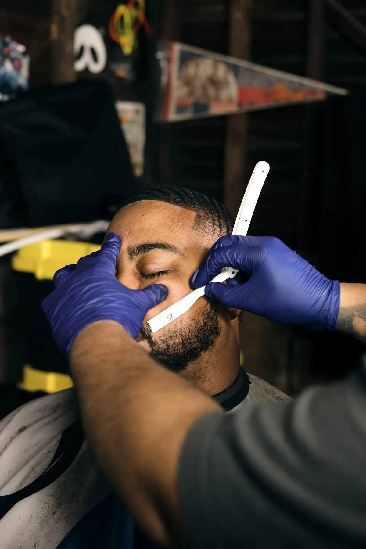 Barbier ganté traçant les contours de la barbe d’un client