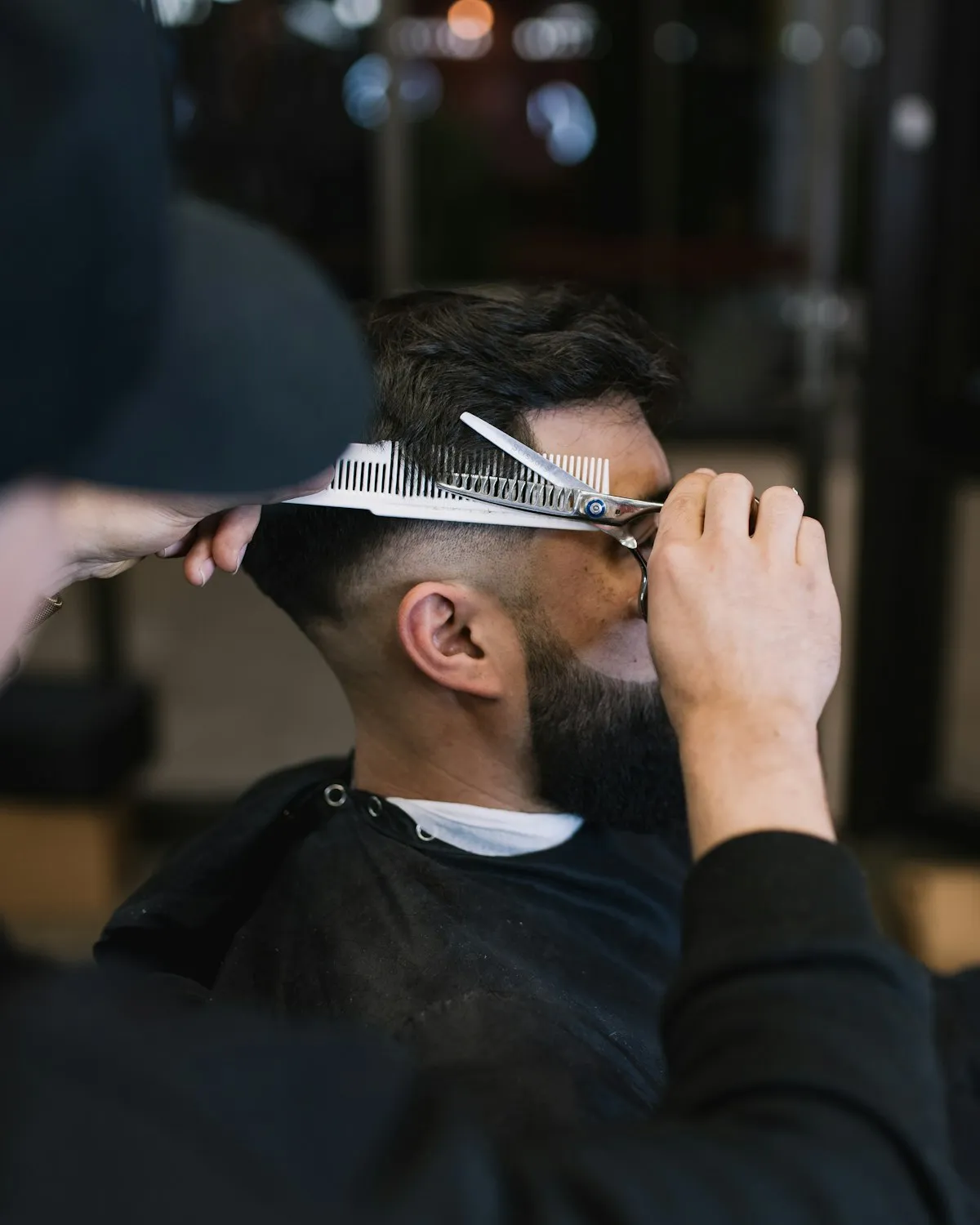Coupe de cheveux réalisée aux ciseaux par un barbier